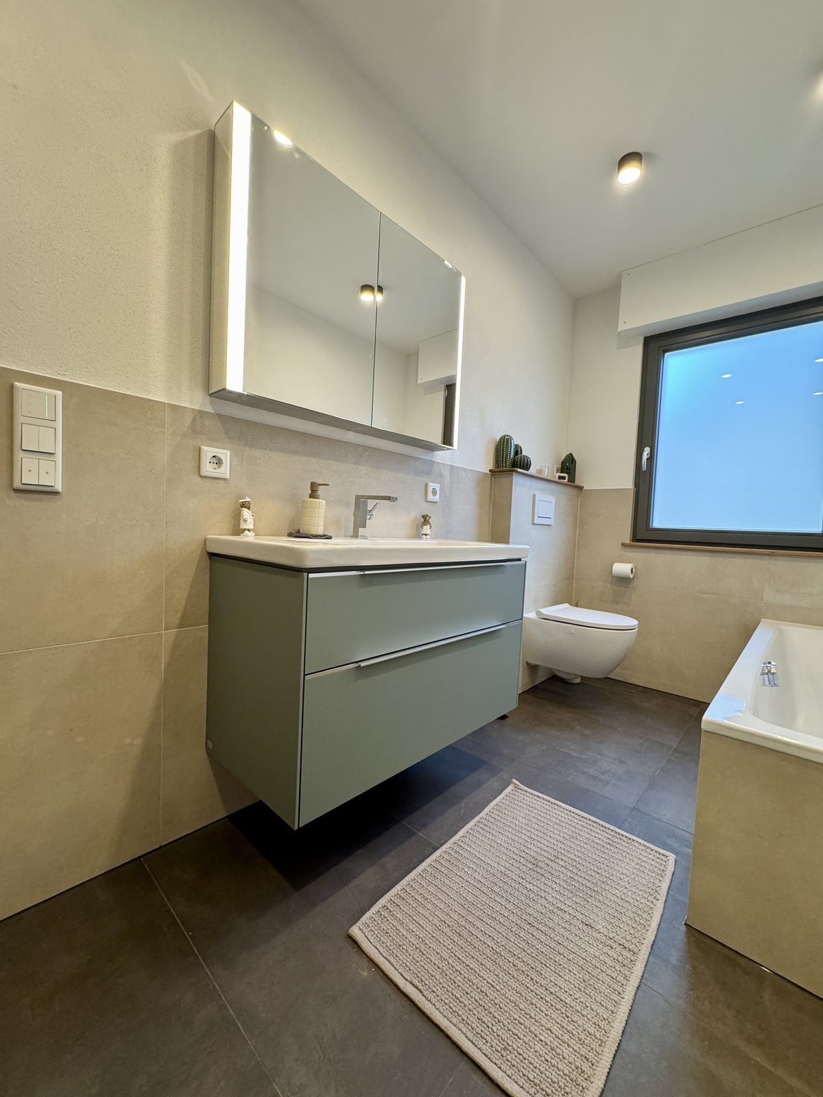 Fertig saniertes Bad mit Waschtisch, Spiegelschrank und freistehender Badewanne