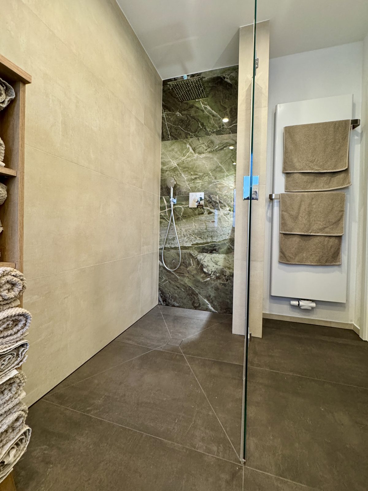 Bodengleiche Dusche mit Naturstein-Optik und Handtuchheizkörper
